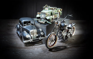 Dramatic image of a replica classic car, military truck and a motorcycle.
