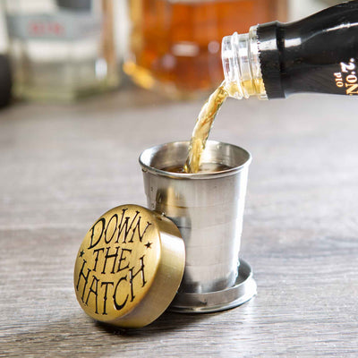 drink pouring in collapsible shot glass includes lid that says down the hatch